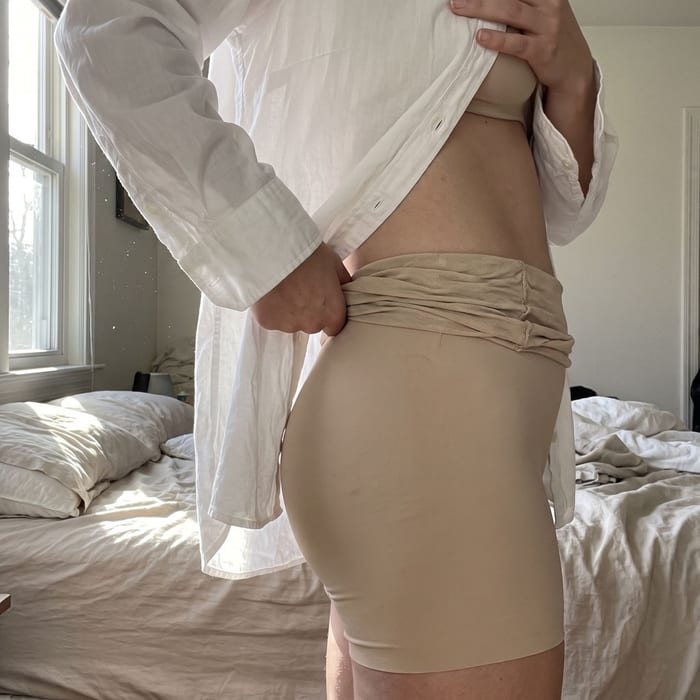 Beige shapewear rolling down at the waist